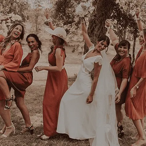 Mariée et demoiselles d'honneur joyeuses en robes élégantes dans un décor champêtre, une sélection Se Casan.